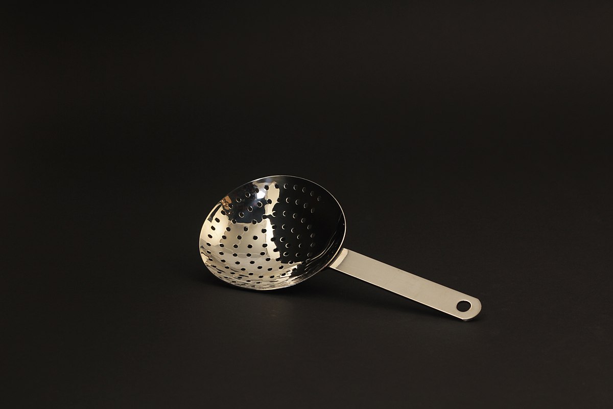 How to use a cocktail strainer - a julep strainer on a black background