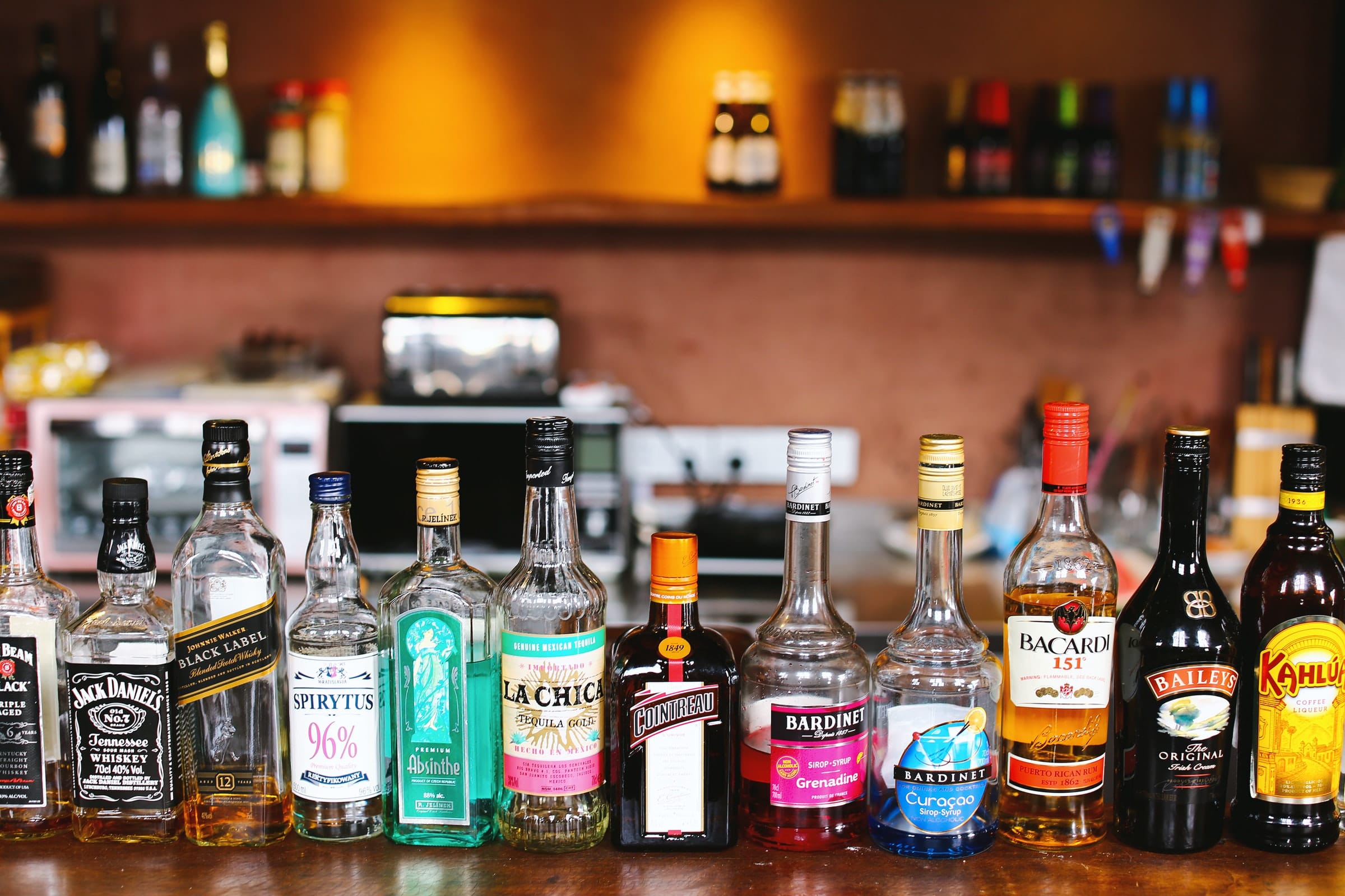 A group of premium spirits, essential products your home bar needs, sit on a wooden table