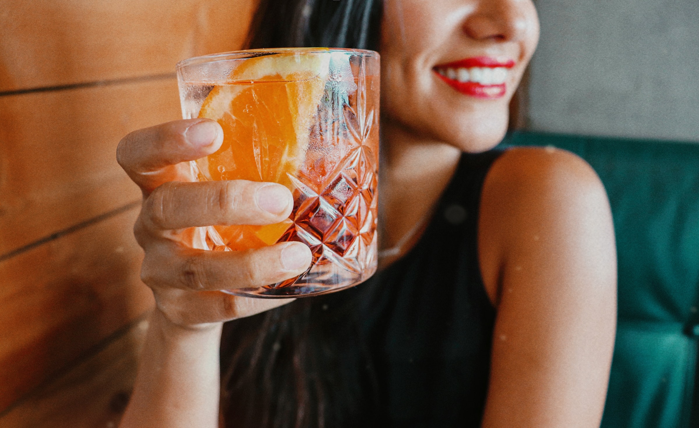 A woman holds a negroni sbagliato