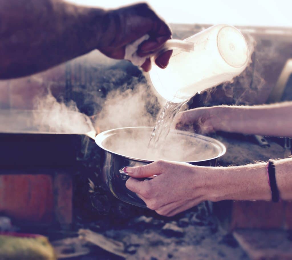 Boiling water poured into a pan as people make sugar free syrup