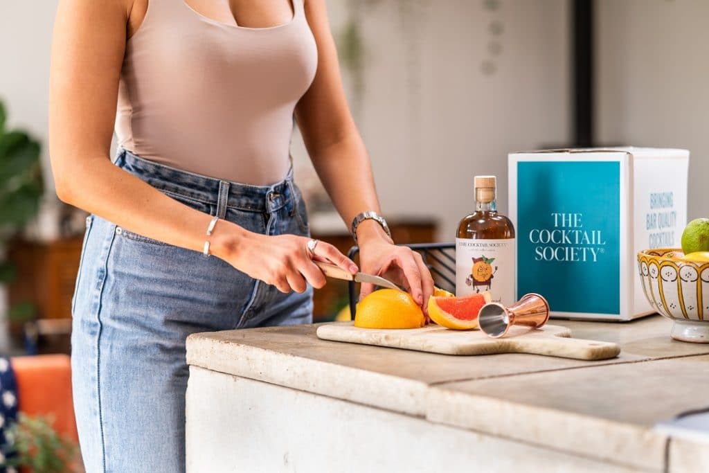 A woman prepares cocktail ingredients from The Cocktail Society's cocktail discovery box