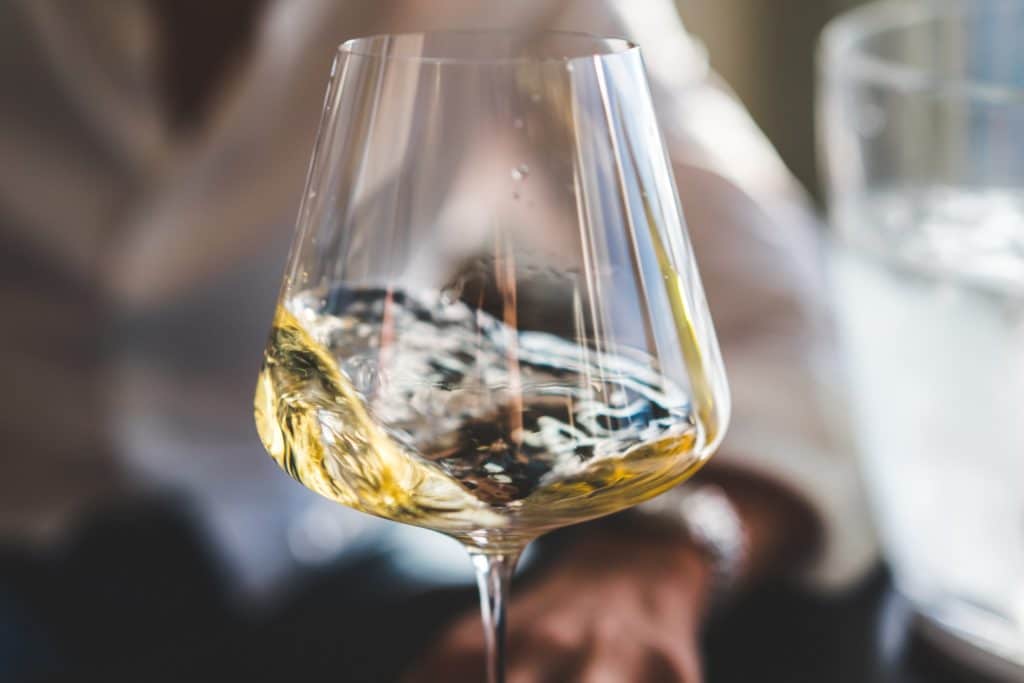 A glass of white wine being swirled