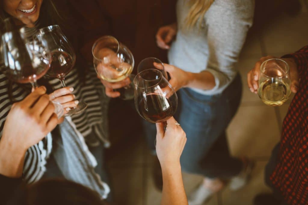 A group of women toast with wine glasses