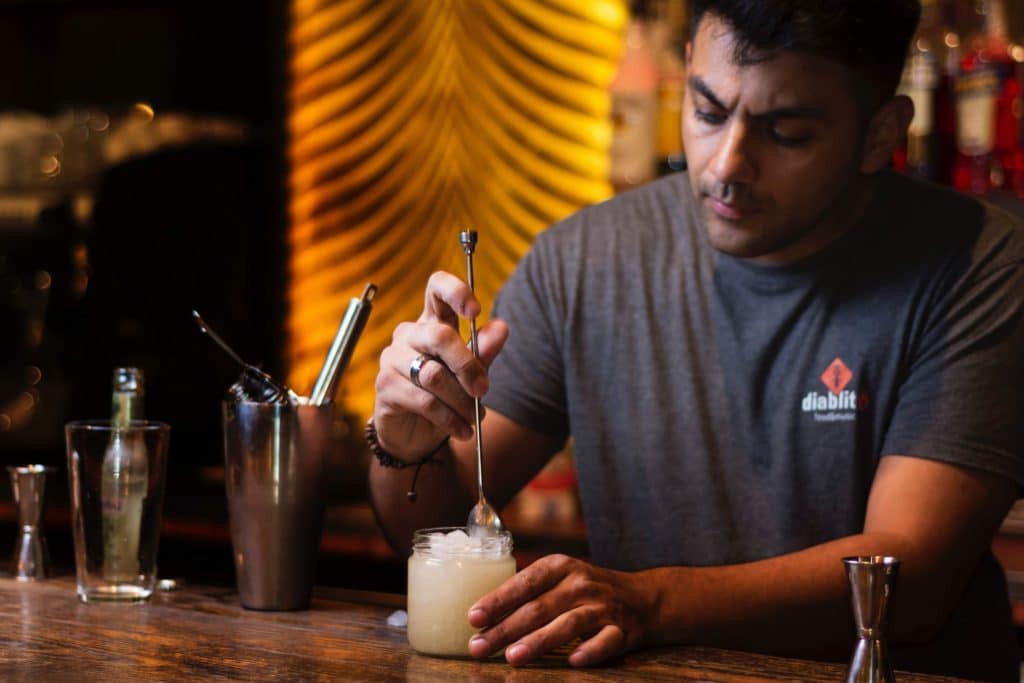 A bartender displays how to stir cocktails in the glass